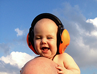 Baby Asher, 8 months old, wearing revo baby earmuffs in orange